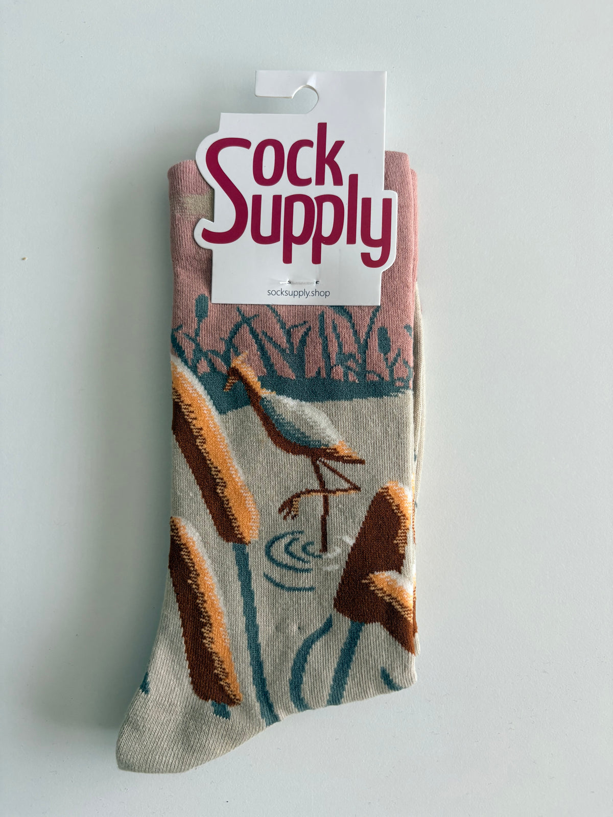 Unisex by Sock Supply features a bird above reeds/cattails socks